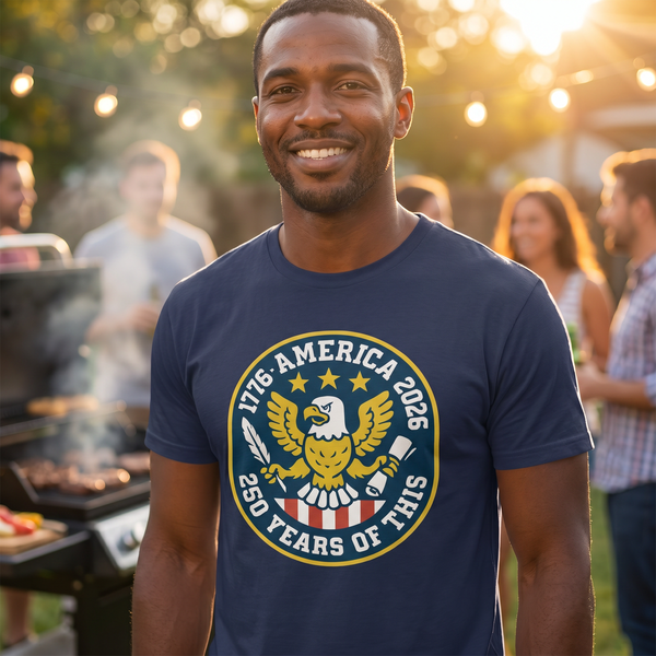 Guy at backyard BBQ wearing America 250 navy eagle badge tee, 1:1 lifestyle
