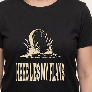 Here Lies My Plans tee worn front view, black unisex tee, leaning headstone sunk in tall weeds
