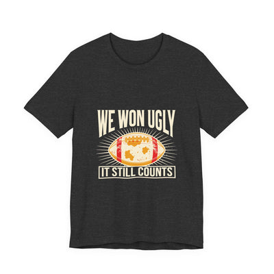 We Won Ugly tee flat front, dark grey heather unisex tee, mud-caked football badge
