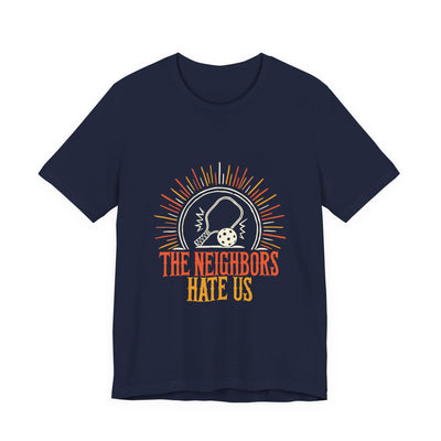 The Neighbors Hate Us tee flat front, navy unisex tee, pickleball paddle sunburst badge