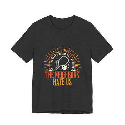 The Neighbors Hate Us tee flat front, dark grey heather unisex tee, pickleball paddle sunburst badge