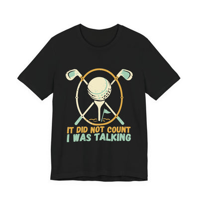 It Did Not Count I Was Talking tee flat front, black unisex tee, two golf clubs crossed behind a ball on a tee
