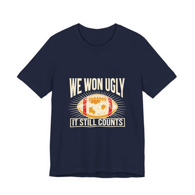 We Won Ugly tee flat front, navy unisex tee, mud-caked football badge