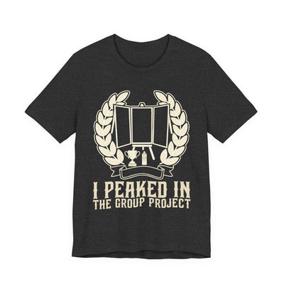 I Peaked In The Group Project tee flat front, dark grey heather unisex tee, a poster board on an easel