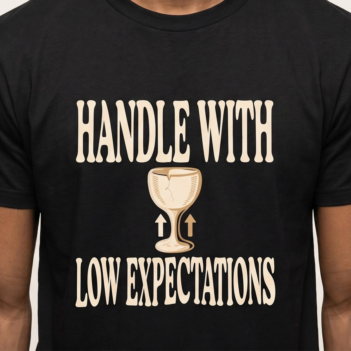 Handle With Low Expectations tee worn front view, black unisex tee, cracked wine glass with arrows