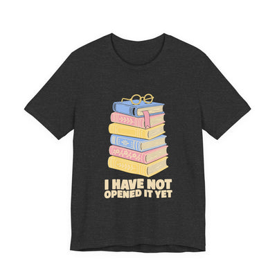 I Have Not Opened It Yet tee flat front, dark grey heather unisex tee, stack of hardback books