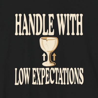 Handle With Low Expectations tee print close-up, black unisex tee, cracked wine glass with arrows
