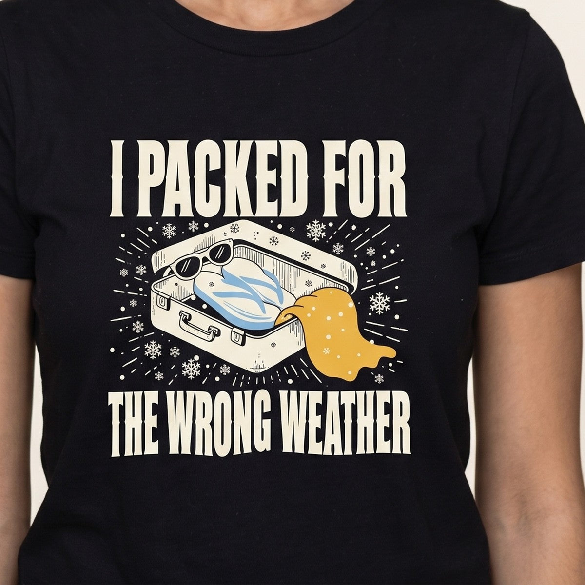 I Packed For The Wrong Weather tee worn front view, black unisex tee, suitcase of beach gear in snow