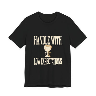 Handle With Low Expectations tee flat front, black unisex tee, cracked wine glass with arrows