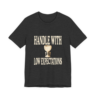 Handle With Low Expectations tee flat front, dark grey heather unisex tee, cracked wine glass with arrows
