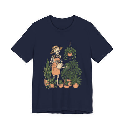 Skeleton Plant Parent tee flat front, navy unisex tee, skeleton in a sun hat watering a monstera and houseplants