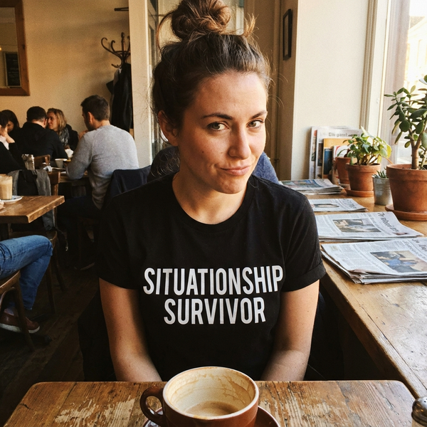 Situationship Survivor graphic tee — lifestyle photo, cafe candid, knowing smirk