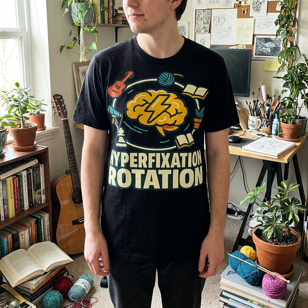 Person wearing Hyperfixation Rotation graphic tee with bold orbital brain design on black shirt