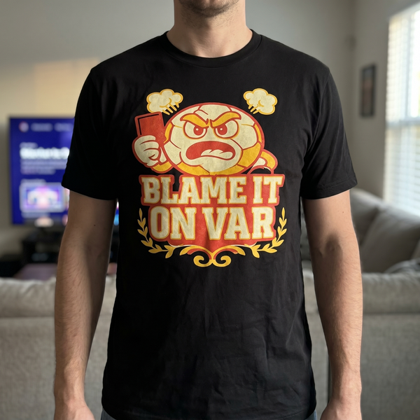 Fan wearing Blame It On VAR black soccer referee humor tee at a match watch party