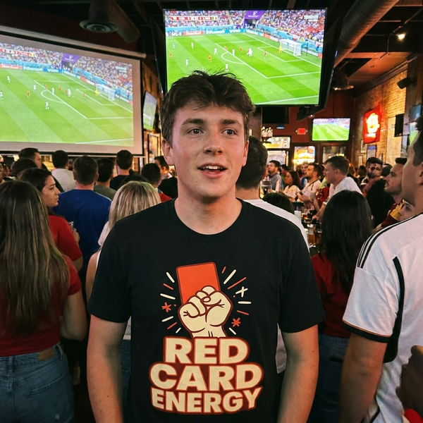 Red Card Energy soccer fan t-shirt, fist holding a red card graphic on a black tee