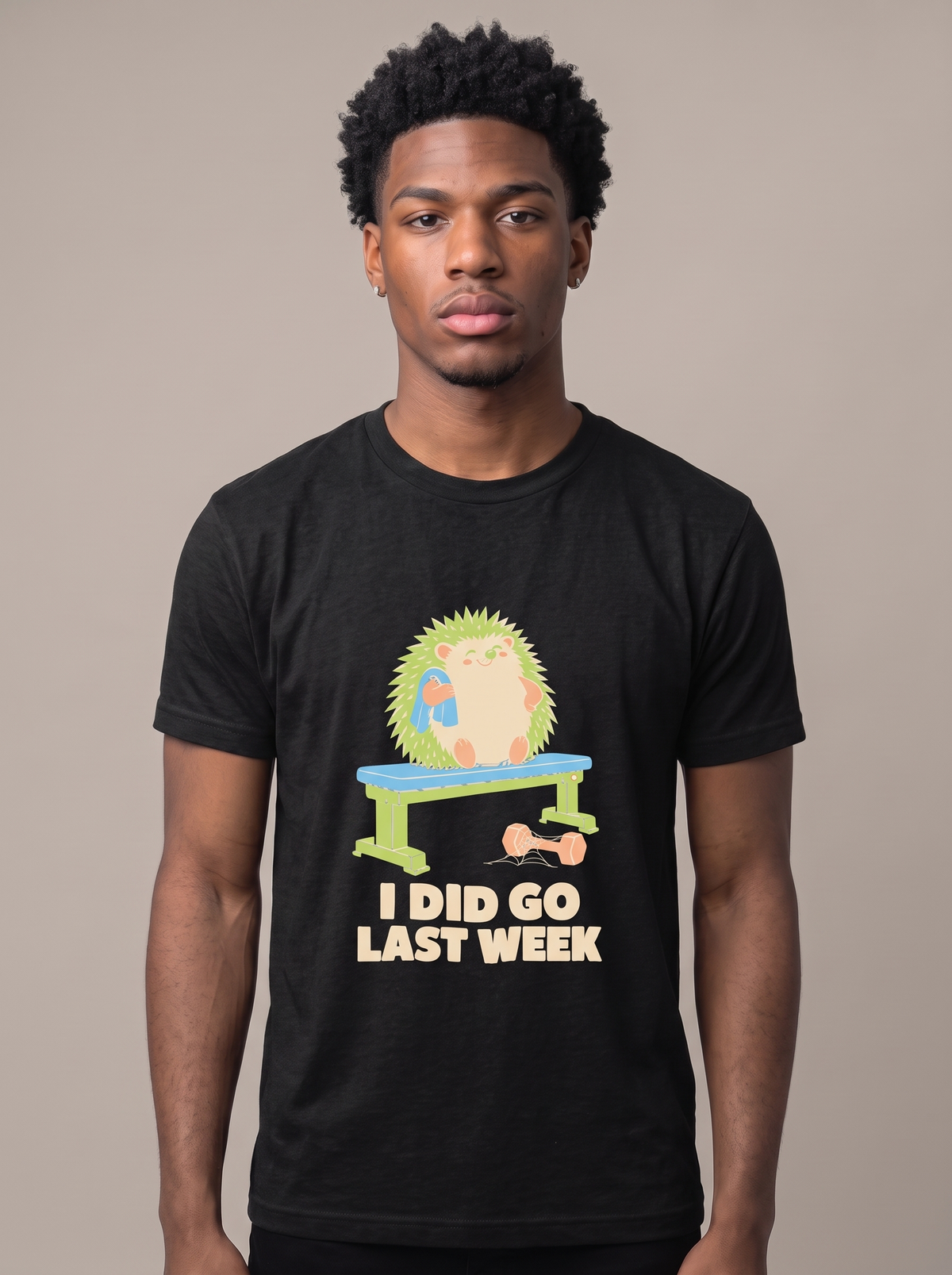I Did Go Last Week tee worn front view, black unisex tee, hedgehog sat on a weight bench