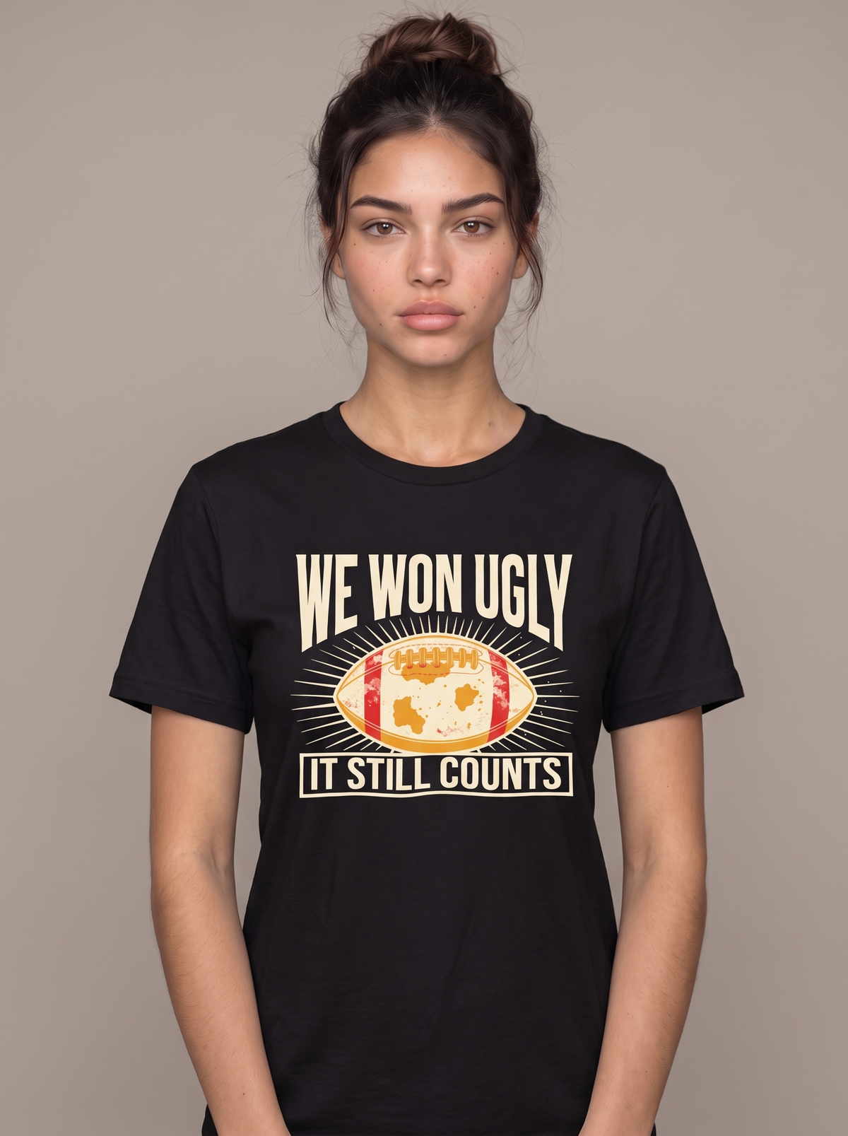 We Won Ugly tee worn front view, black unisex tee, mud-caked football in a radiating badge