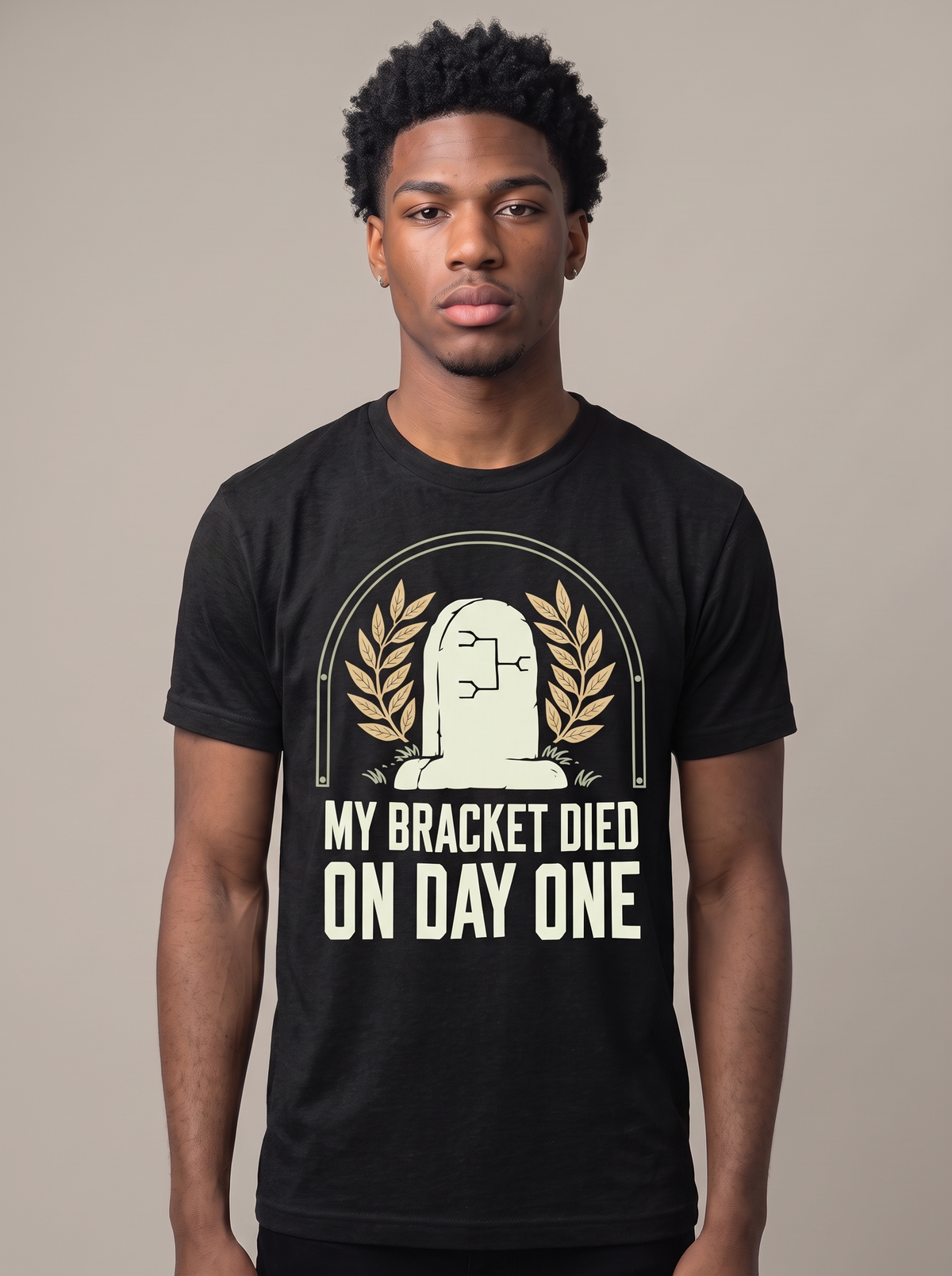 My Bracket Died On Day One tee worn front view, black unisex tee, a headstone with a bracket diagram carved on it
