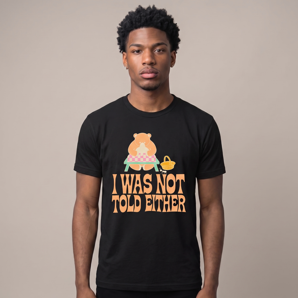 I Was Not Told Either tee worn front view, black unisex tee, bear at an empty picnic table